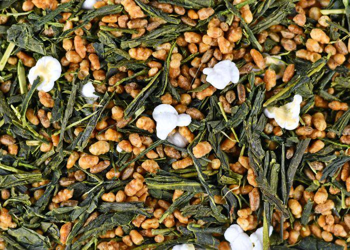 A close-up of Japanese genmaicha tea, showing the dried tea leaves, roasted brown rice and the popped corn.